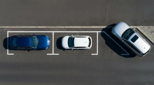 Vue aérienne montrant trois types de manœuvres de stationnement avec voitures colorées