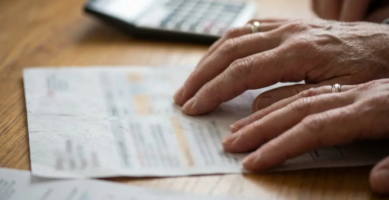 Couple à table examinant des documents d'assurance avec calculatrice