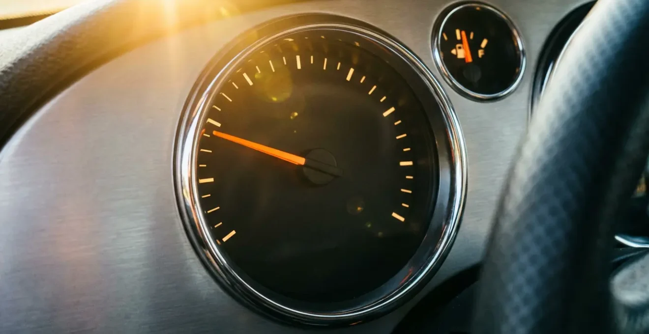 Vue macro d'un tableau de bord automobile moderne avec compte-tours et indicateur de consommation