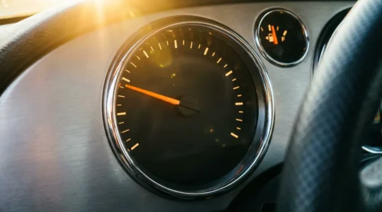 Vue macro d'un tableau de bord automobile moderne avec compte-tours et indicateur de consommation