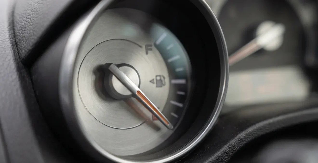 Tableau de bord de voiture montrant l'aiguille de consommation de carburant, illustrant l'augmentation due au poids des bagages.