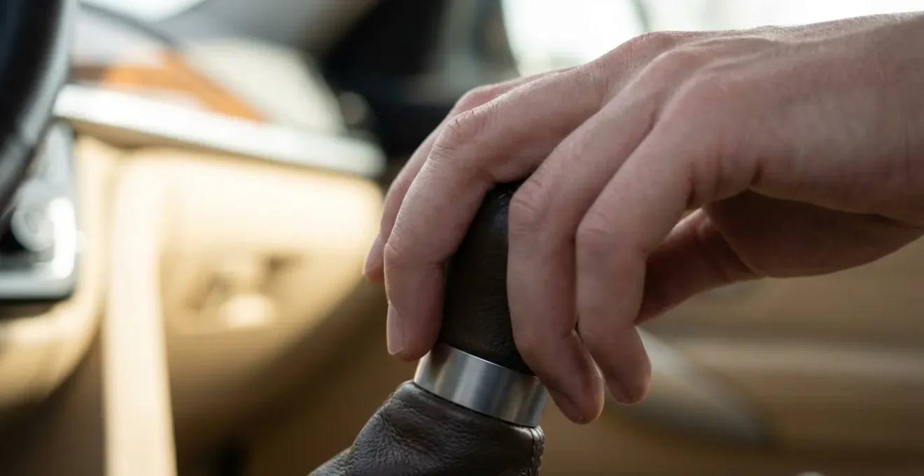 Gros plan sur une main experte manipulant un levier de vitesse avec douceur et précision